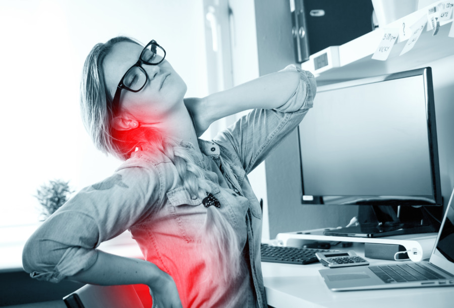 Eine Frau mit Schmerzen am Arbeitsplatz. Mit Gesundheitsvorsorge muss es nicht soweit kommen. (Foto: AdobeStock©leszekglasner)